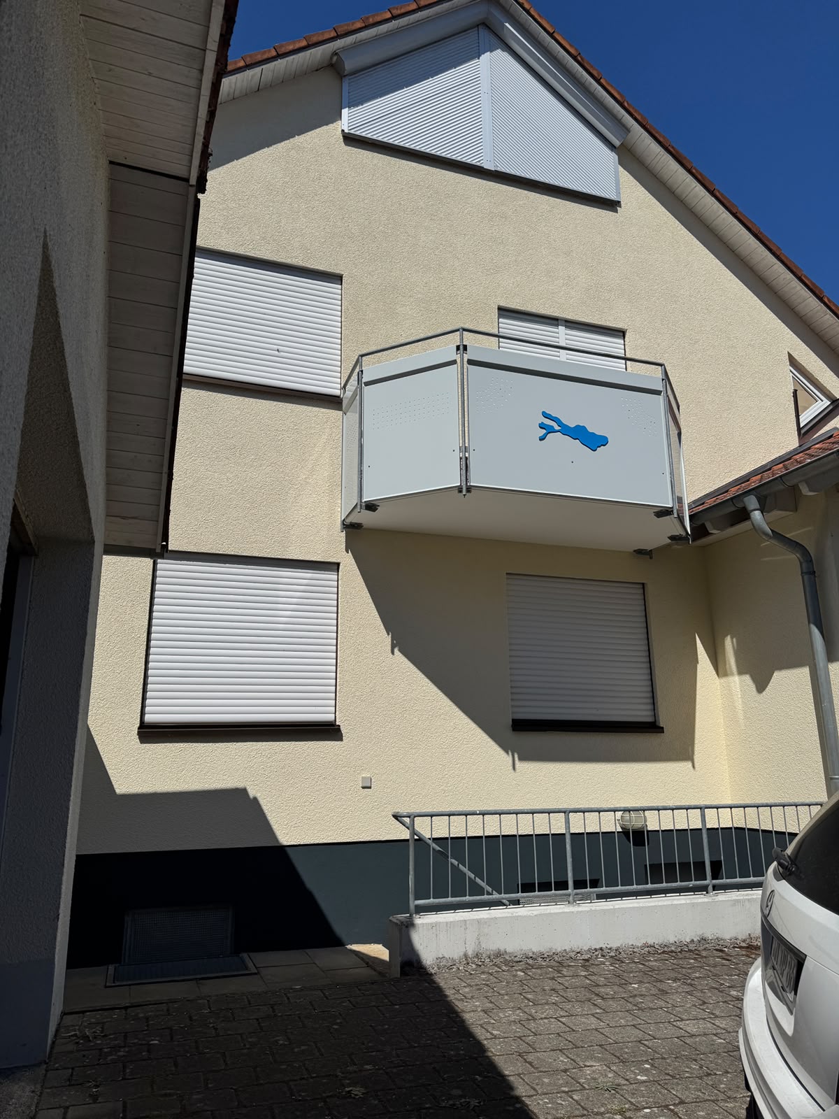 Frisch gestrichene Fassade mit neu gestrichenem Holzgiebel und dunklem Haussockel