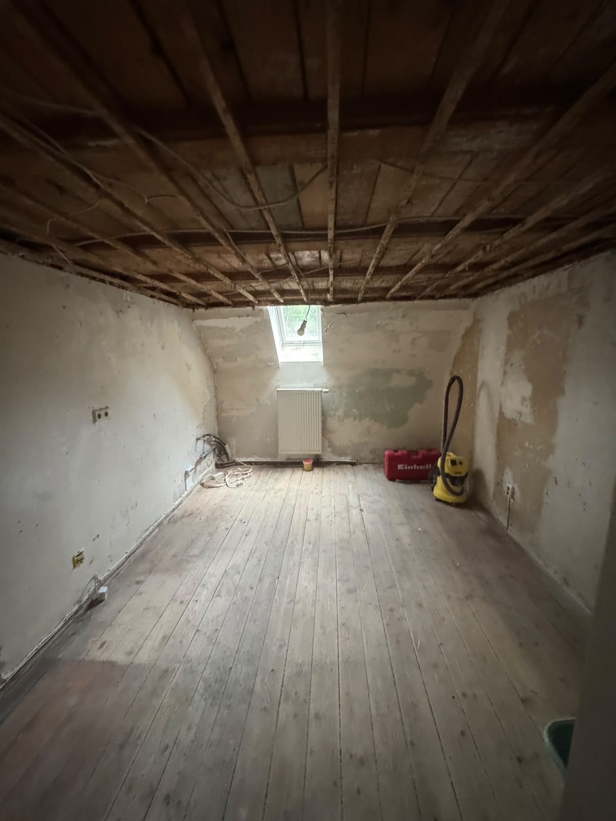 Küche nach dem Rückbau: freigelegte Holzdecke, alter Dielenboden und Putzwände vor der Sanierung